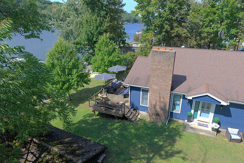 Angled drone photo of a lakefront home showing the water view from the property
